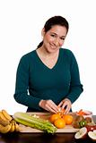 Woman in kitchen peeling orange