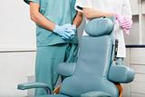 Dentist and female assistant in exam room by dentist's chair