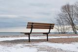 Empty Park Bench by a Lake in Winter