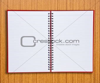 Red notebook on wooden background