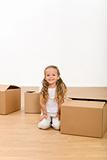 Little girl among cardboard boxes