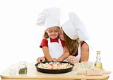 Woman and little girl making pizza