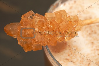 Macro shot of sugar stick on cafe latte