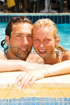 attractive young couple relaxing by the pool