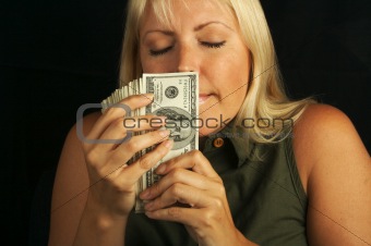 Attractive Woman Smells Her Stack of Money.