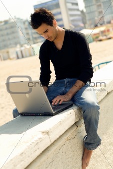 Young attractive man with laptop outdoor