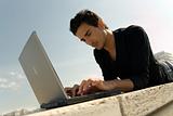 Young man working with laptop outdoor