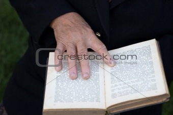 Senior's hands on old book