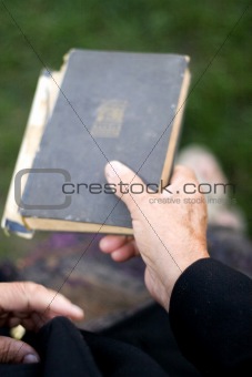 Senior's hands on old book