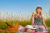 young girl reading book and eating apple