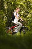 young woman with bicycle in forest