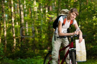 young woman with bicycle in forest