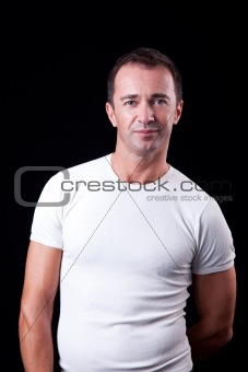 Portrait of a handsome middle-age man smiling, on black background. Studio shot