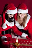 two woman in Santa costume opening christmas gift. 