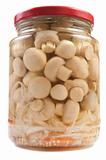 Marinaded mushrooms in a glass jar .