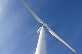Single wind turbine against blue sky