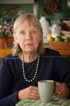 Depressed senior woman with mug