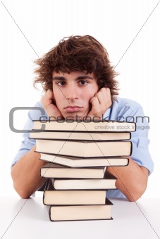 cute boy bored, among books, on his desk, isolated on white, studio shot