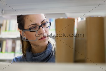 woman choosing book in library