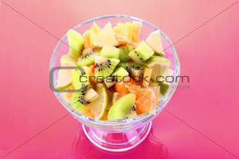 Cup with orange, kiwi and lime on red