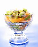 Cup with orange, kiwi and lime on blue