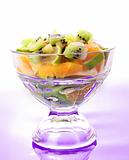 Cup with orange, kiwi and lime on violet 