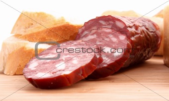 Sausage and bread on wooden surface