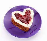 sweet cake in heart shape on violet plate
