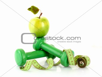 Dumbbells, green apple and measuring tape  isolaeted on white
