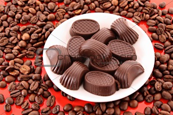 Chocolate and coffee beans on red background