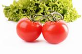 Two tomatos and salad isolated on white