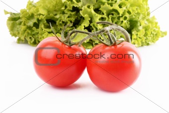 Two tomatos and salad isolated on white