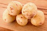Few potatoes on wooden surface
