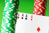 Casino chips and aces against green background
