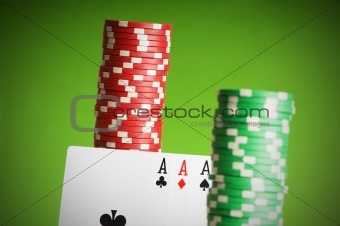 Casino chips and aces against green background