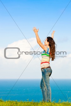 Beautiful young woman with her arms in the air