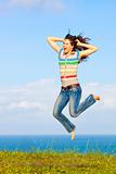 Beautiful young woman jumping up in the air laughing 