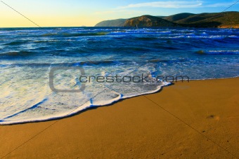 Sand on the Aegean coast and the mountains far away