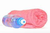 Twisted red towel and bottle of sparkling water isolated on whit