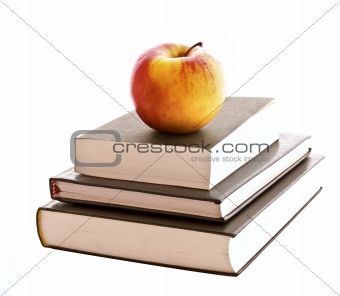 Three books and apple isolated on white