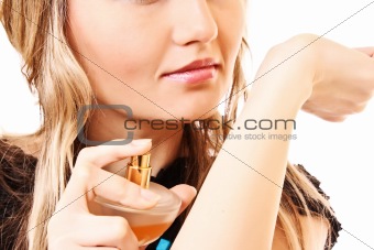Young woman with a bottle of perfume isolated on white