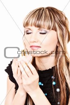 Young woman with a bottle of perfume isolated on white