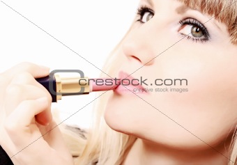 beautiful young girl making up her lips with lipstick
