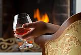 Resting at the burning fireplace fire with a glass of cognac
