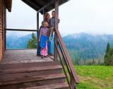 Family on wooden mountain cottage porch