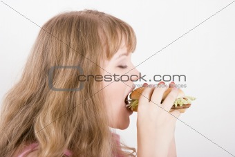 The girl bites a hamburger