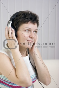 The girl listens to music in ear-phones