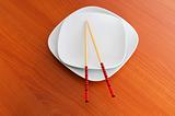 Plate with chopsticks on the wooden table