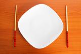 Plate with chopsticks on the wooden table
