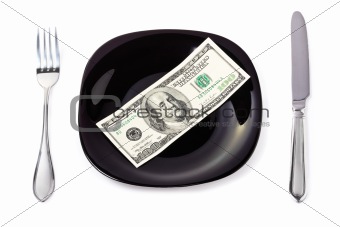 Banknote on a black plate with knife and fork